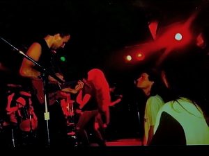 A band performing on stage in front of a crowd.