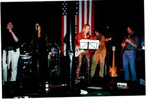 A group of people on stage with instruments.