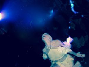 A person in white dress and blue light