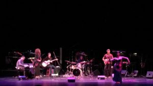 A band performing on stage with instruments.