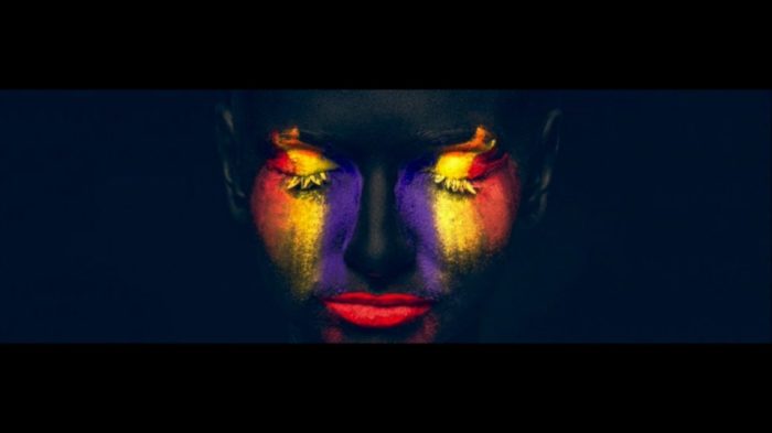 A woman with bright makeup on her face.