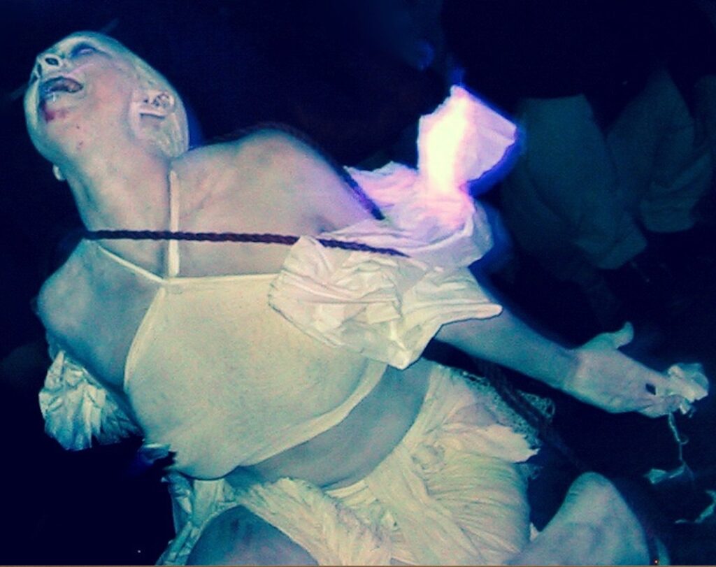 A ballet dancer performs an elegant underwater routine in a flowing dress.